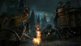 The player hunter in Bloodborne crouched with a torch, a werewolf-like creature stalking them nearby in Bloodborne.