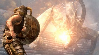 A player character in Skyrim is holding up a shield, preparing to be hit by a breath of fire from a dragon.