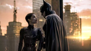 Batman is stood in a building overlooking Gotham at sunset while holding onto Catwoman's arm in The Batman.